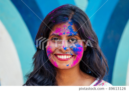 Holi Festival Of Colours. Portrait of happy indian girl in holi color. snow white smile and perfect hairstyle Holi Festival Of Colours. Portrait of happy indian girl in holi color. snow white smile and perfect hairstyle 89613126
