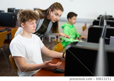 Teacher is dissatisfied with student during classes in the computer class of school Teacher is dissatisfied with student during classes in the computer class of school 89613251