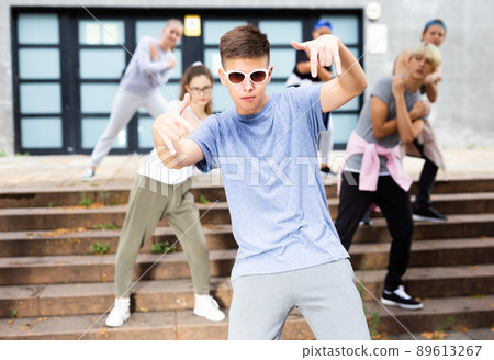 Happy smiling teenagers practicing vigorous hip hop movements at street Happy smiling teenagers practicing vigorous hip hop movements at street 89613267