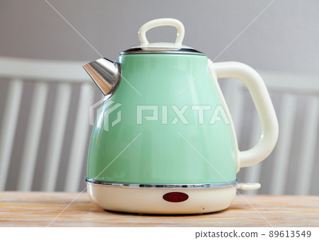 Turquoise electric tea kettle on wooden table 89613549