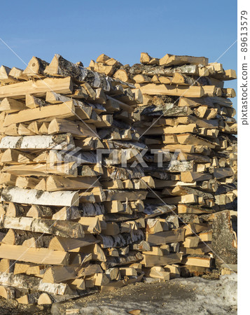 Pricked firewood built in stack of logs on background blue sky Pricked firewood built in stack of logs on background blue sky 89613579