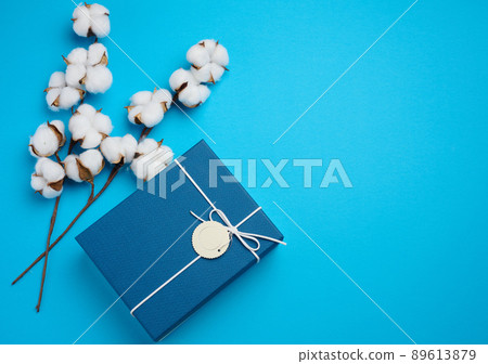 Cardboard box for gifts and a twig with cotton flowers on a blue background, top view Cardboard box for gifts and a twig with cotton flowers on a blue background, top view 89613879