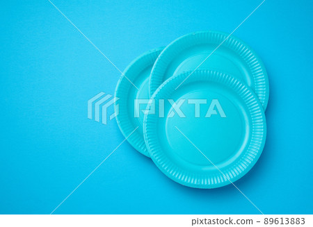 Empty white paper disposable plates on a bluen background, top view. The concept of rejection of plastic, environmental conservation Empty white paper disposable plates on a bluen background, top view. The concept of rejection of plastic, environmental conservation 89613883