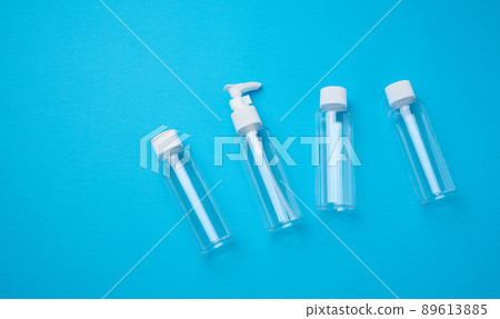 Various transparent empty plastic bottles and jars for cosmetics on a blue background, top view Various transparent empty plastic bottles and jars for cosmetics on a blue background, top view 89613885