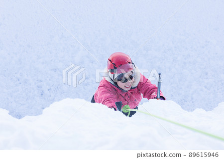 A woman enjoying ice climbing 89615946