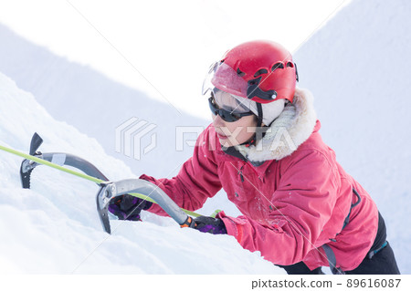A woman enjoying ice climbing 89616087