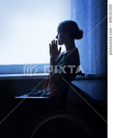 Disabled person in stroller by window 89616309