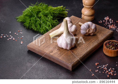 Heads of fresh white garlic on a wooden cutting board 89616444