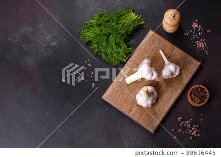 Heads of fresh white garlic on a wooden cutting board 89616445