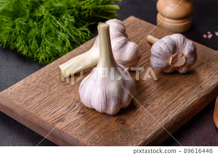 Heads of fresh white garlic on a wooden cutting board Heads of fresh white garlic on a wooden cutting board 89616446