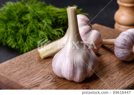 Heads of fresh white garlic on a wooden cutting board Heads of fresh white garlic on a wooden cutting board 89616447