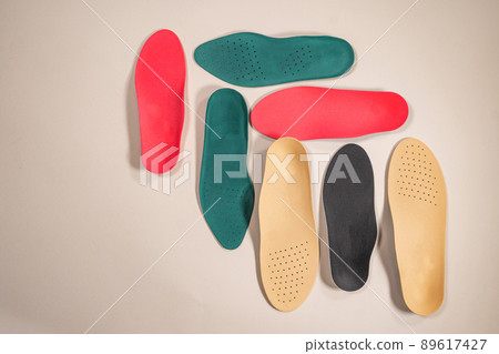 Orthopedic insoles for shoes on a colour background. Foot care Orthopedic insoles for shoes on a colour background. Foot care 89617427