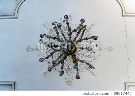 Round antique vintage decorative clay stucco relief molding with floral ornaments on white ceiling in abstract classical style interior 89617443