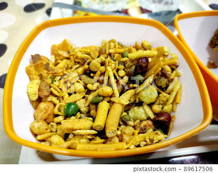 Close up of plane salty Golden Mixture Indian namkeen (snacks) on a ceramic black bowl. Top view 89617506
