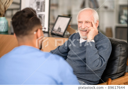 Happy elderly person talking to his in-home caregiver Happy elderly person talking to his in-home caregiver 89617644