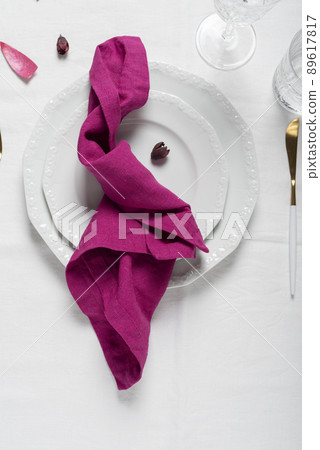 Fuchsia linen napkin on the white dish Fuchsia linen napkin on the white dish 89617817