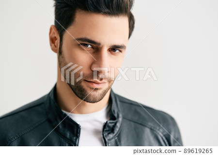 Closeup portrait of handsome trendy man posing on white studio background Closeup portrait of handsome trendy man posing on white studio background 89619265