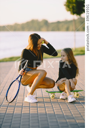 Mother and daughter spend time together. Taking time in a park with skateboard. Summer. Mother and daughter spend time together. Taking time in a park with skateboard. Summer. 89619501