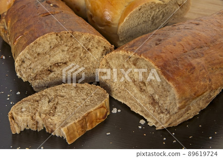 Bread in the shape of a braid. Sweet Challah. Slice of banana bread for breakfast, side view. Cherry tomatoes  89619724