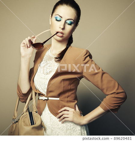 Portrait of beautiful young woman with a leather bag 89620481