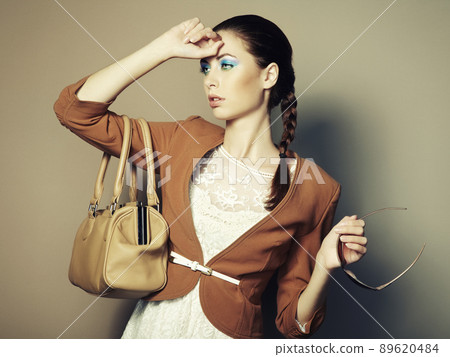Portrait of beautiful young woman with a leather bag Portrait of beautiful young woman with a leather bag 89620484