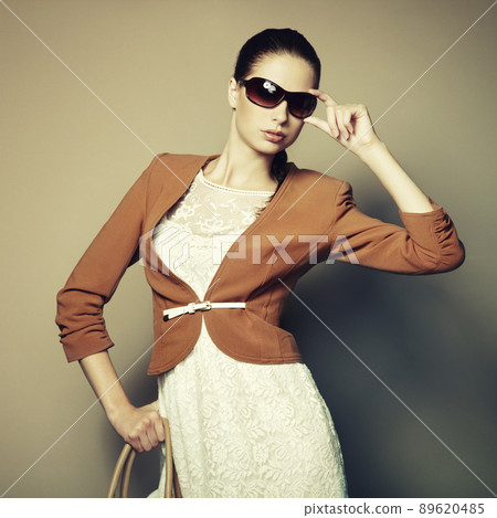 Portrait of beautiful young woman with a leather bag Portrait of beautiful young woman with a leather bag 89620485