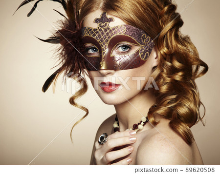 Beautiful young woman in brown mysterious venetian mask Beautiful young woman in brown mysterious venetian mask 89620508