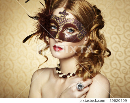 Beautiful young woman in brown mysterious venetian mask Beautiful young woman in brown mysterious venetian mask 89620509