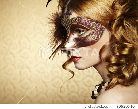 Beautiful young woman in brown mysterious venetian mask 89620510