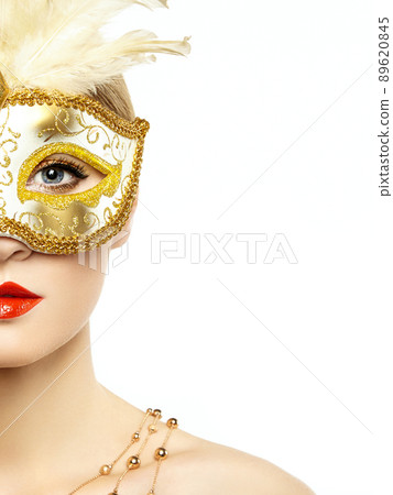 Beautiful young woman in mysterious golden Venetian mask Beautiful young woman in mysterious golden Venetian mask 89620845