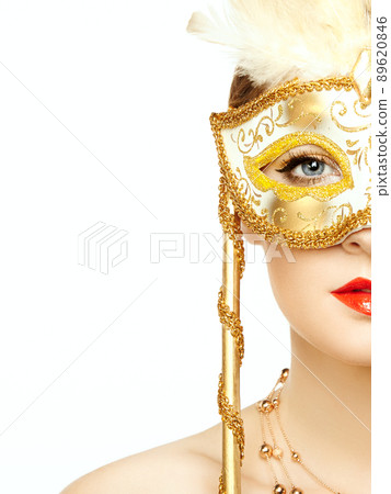 Beautiful young woman in mysterious golden Venetian mask 89620846