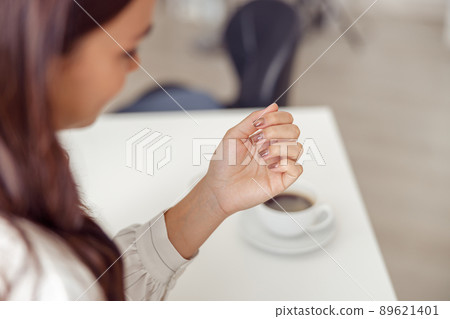 Female client enjoying groomed hands in nail salon Female client enjoying groomed hands in nail salon 89621401