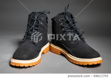 Pair of black winter men's boots on a gray background Pair of black winter men's boots on a gray background 89621705