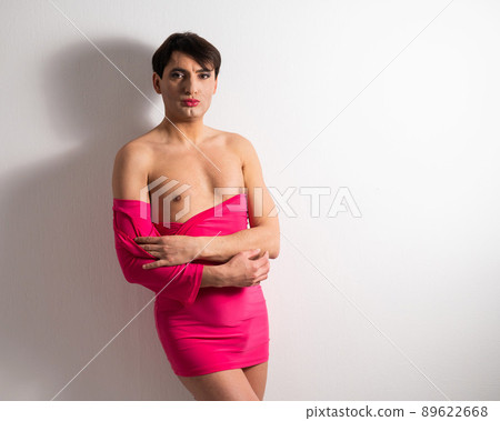 Homosexual in a pink female dress. A man in make-up. 89622668
