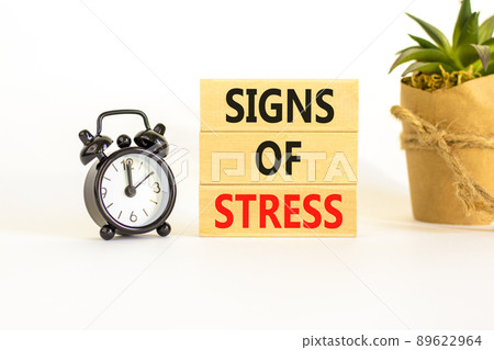 Signs of stress symbol. Concept words Signs of stress on wooden blocks. Black alarm clock. Beautiful white table white background. Psychological business and signs of stress concept. Copy space. 89622964