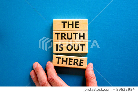 The truth is out there symbol. Concept words The truth is out there on wooden blocks. Businessman hand. Beautiful blue table blue background. The truth is out there business concept. Copy space. 89622984