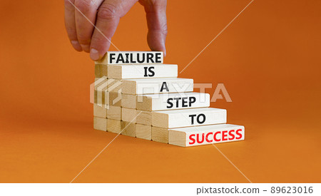 Failure or success symbol. Wooden blocks with words A failure is a step to success. Beautiful orange table orange background. Businessman hand. Business, failure or success concept. Copy space. Failure or success symbol. Wooden blocks with words A failure is a step to success. Beautiful orange table orange background. Businessman hand. Business, failure or success concept. Copy space. 89623016