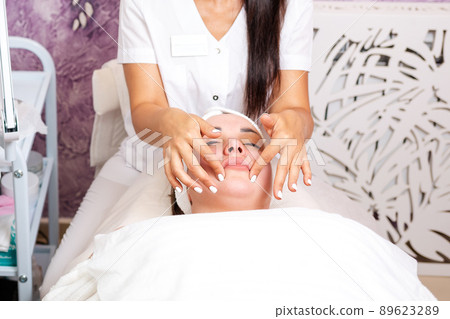 Cosmetology. A cosmetologist makes the client a massage procedure. Copy space. Concept of professional care in beauty salons Cosmetology. A cosmetologist makes the client a massage procedure. Copy space. Concept of professional care in beauty salons 89623289