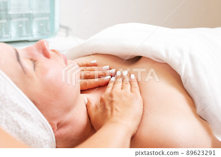 Cosmetologist makes a woman a decollete massage procedure. Close up of decolette. Concept of cosmetology and treatment 89623291