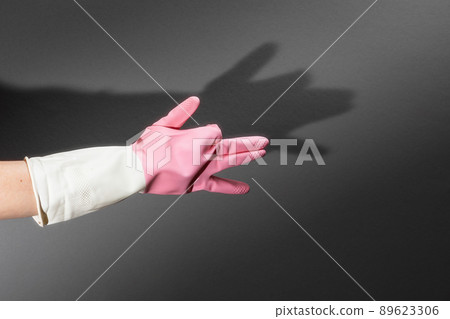 Shadow theater. Hands in rubber gloves shows the figure of a dog. On the dark wall is a shadow of hands in the shape of a dog's head. Copy space Shadow theater. Hands in rubber gloves shows the figure of a dog. On the dark wall is a shadow of hands in the shape of a dog's head. Copy space 89623306