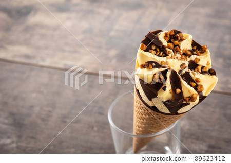 Vanilla and chocolate ice cream cone on wooden table. Copy space Vanilla and chocolate ice cream cone on wooden table. Copy space 89623412