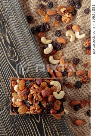 Mix of nuts and raisins on a wooden table. 89623881