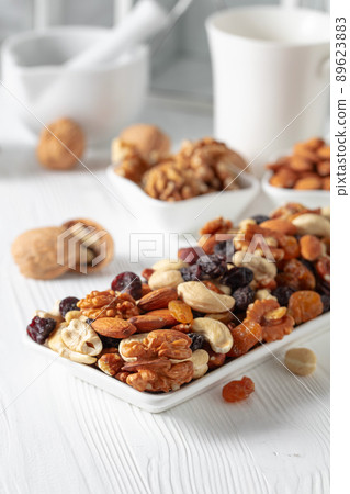 Mix of nuts and raisins on a white wooden table. Mix of nuts and raisins on a white wooden table. 89623883