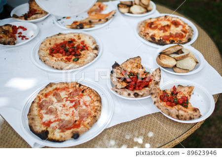 Pizzas on the table in plastic plates 89623946