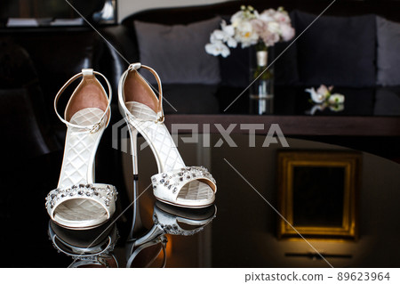 Wedding shoes with jewels on a mirror table Wedding shoes with jewels on a mirror table 89623964