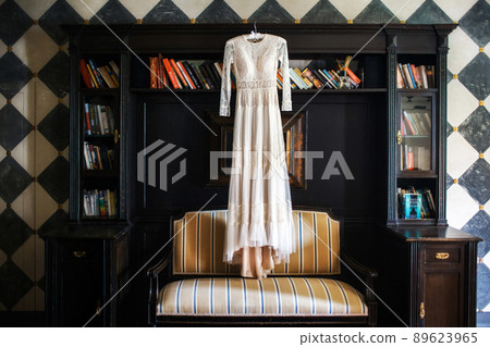 Wedding dress hanging on the wall in the room 89623965