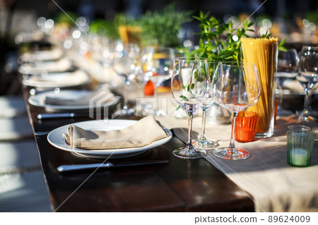 Table set for wedding or another catered event dinner. Italian villa Table set for wedding or another catered event dinner. Italian villa 89624009