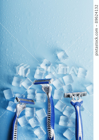 Three shaving machines on a frosty blue background with ice. The concept of cleanliness and frosty freshness Three shaving machines on a frosty blue background with ice. The concept of cleanliness and frosty freshness 89624132