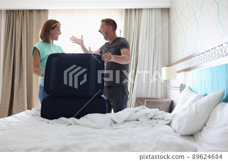 Wife and husband screaming on each other and argue, pack stuff in suitcase, couple fight Wife and husband screaming on each other and argue, pack stuff in suitcase, couple fight 89624684