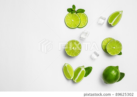Flat lay composition with fresh juicy limes, mint and ice cubes on white background 89625302